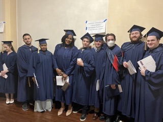 Group of college graduates in their gowns posing for a picture.