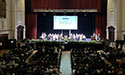 photo of graduation stage with students seated on the floor