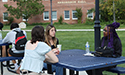 students sit outside at picnic table