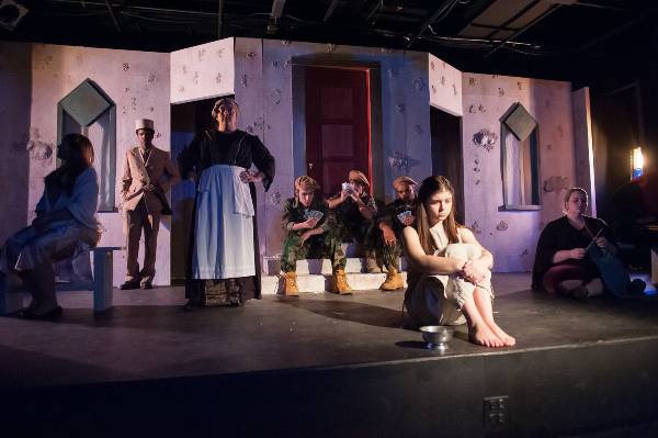 opening tableau, antigone sits downstage surrounded by cast