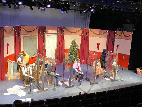 its a wonderful life a radio play, the voice actors sit upon stools with their script pages on the stage floor